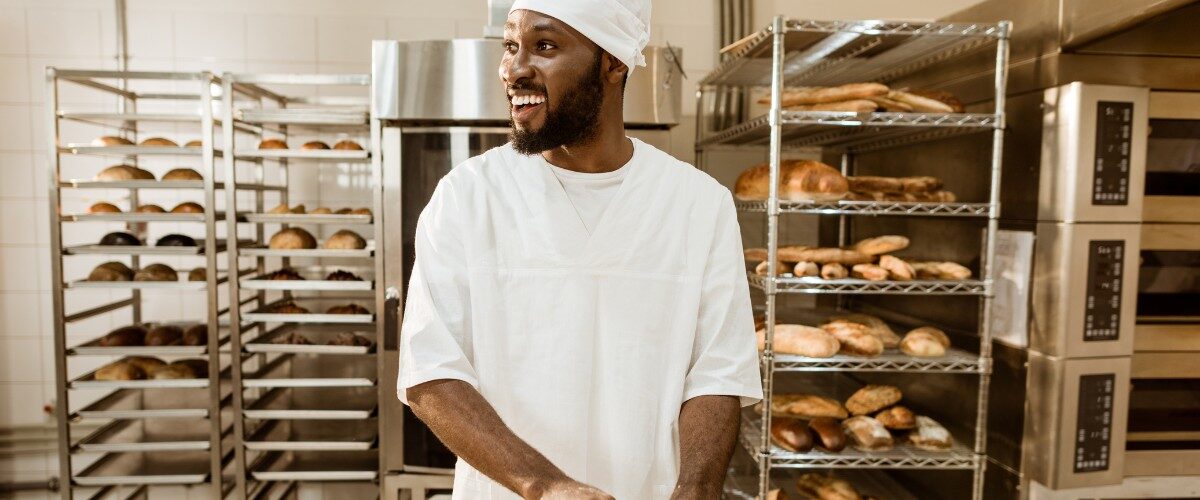 Bakery business challenges in Nigeria showing bakery owner managing equipment, flour, and power issues in a small bakery.