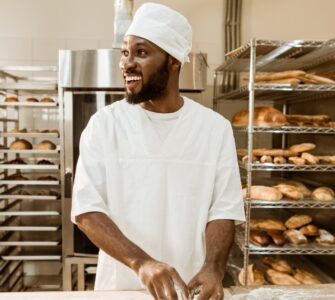 Bakery business challenges in Nigeria showing bakery owner managing equipment, flour, and power issues in a small bakery.